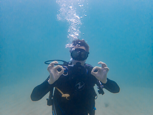 Plongeur faisant le signe OK pendant son baptême de plongée.