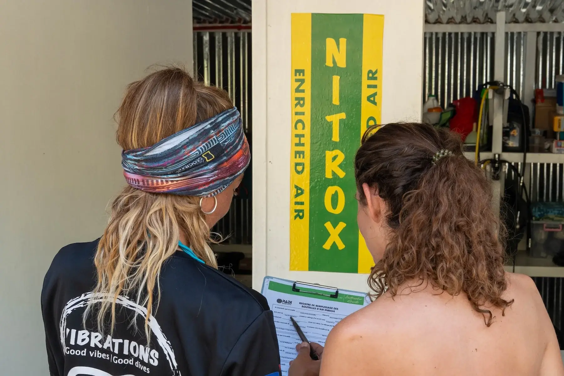 Alumno e instructor PADI analizando una botella durante un curso de Nitrox en Siquijor.
