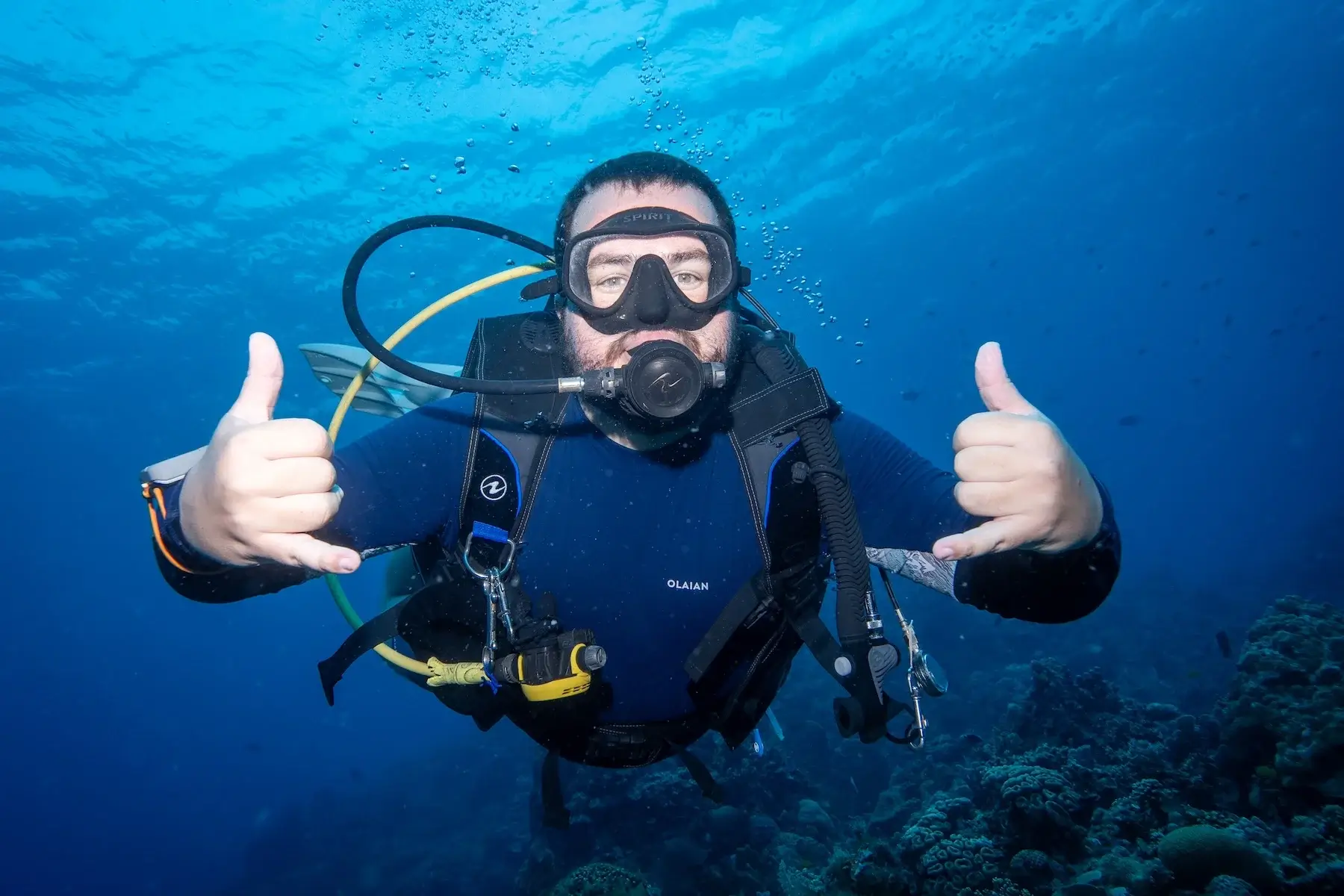 Buceador haciendo el gesto shaka durante un curso PADI Open Water en Siquijor, Filipinas